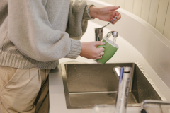 someone rinsing a mug