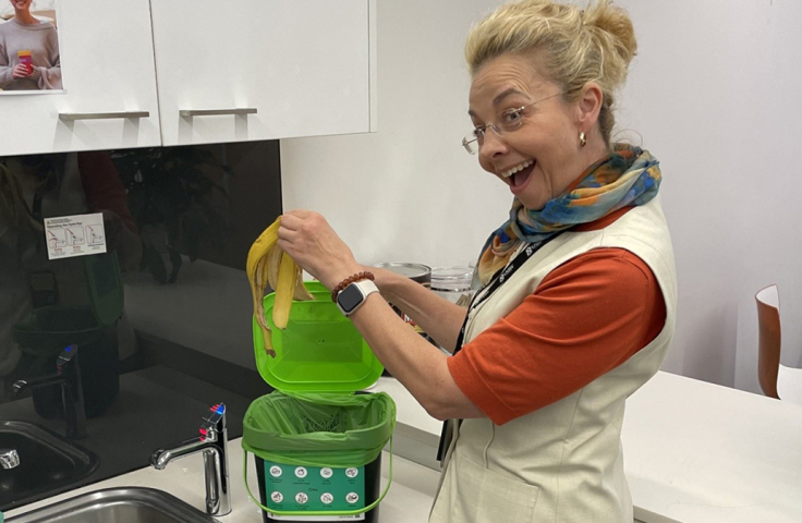 one women placing banana peel in food waste bin
