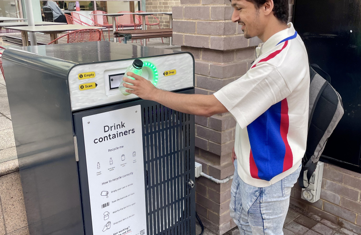 Student dropping bottle into smart bin