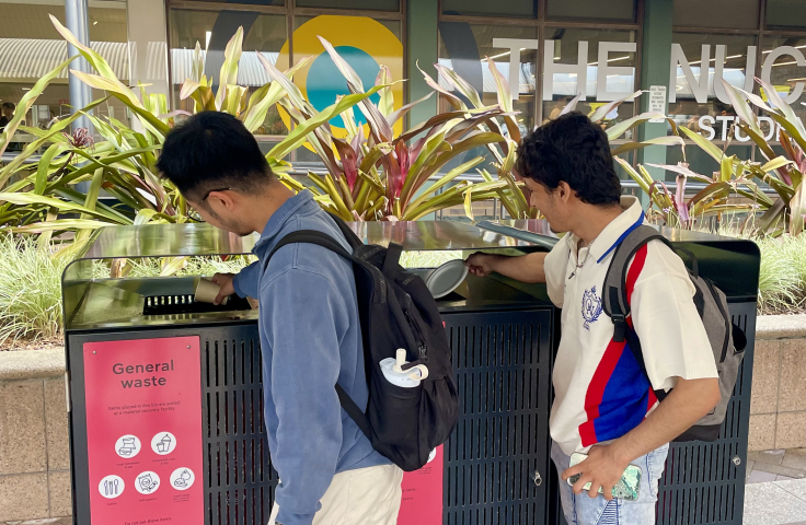 Students dropping waste into red bins