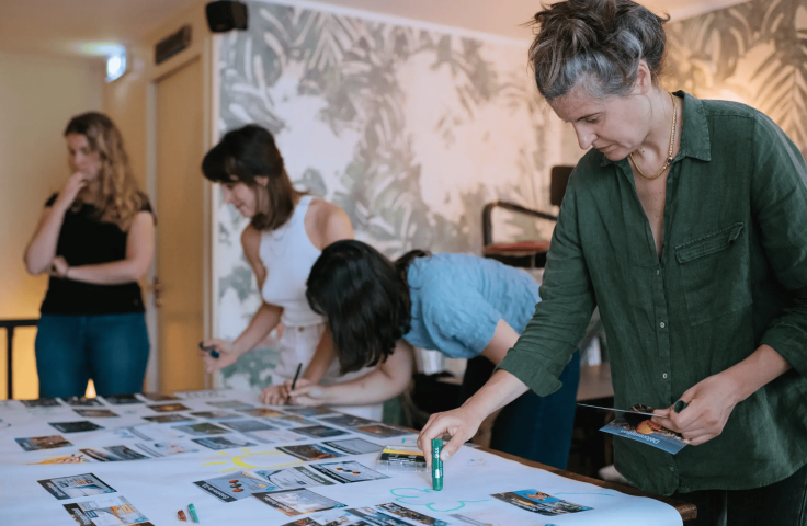 4 women drawing and assembling cards on a table
